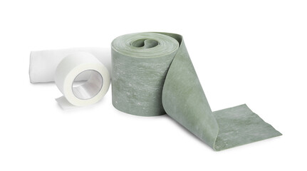 Medical bandage rolls and sticking plaster on white background