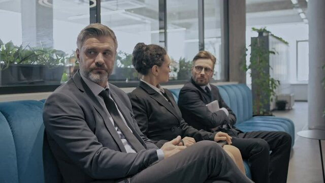Distressed employees waiting for meeting with strict company boss, stressful job