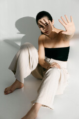  woman sitting on the floor indoors fashionable clothes bright light