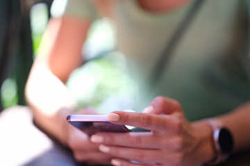 Woman holding modern smartphone in hands closeup