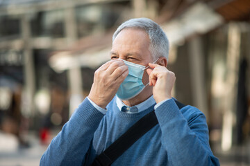 Masked man walking outdoor to go at work, coronavirus people lifestyle concept