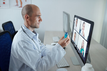 Chef doctor discussing new vaccine against coronavirus with colleagues from other hospitals during online meeting