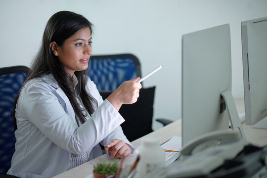 Young Scientist Or Medical Laboratory Worker Pointing At Computer Screen When Analyzing Chart Or Research Data