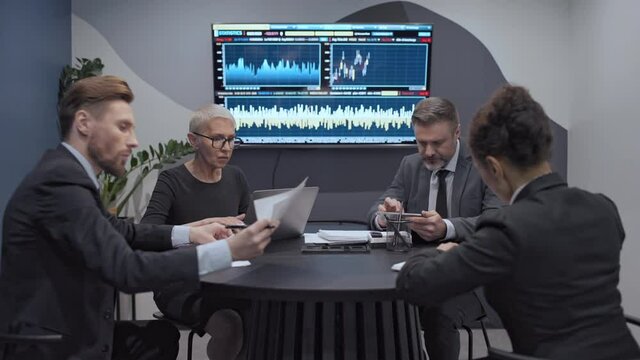 Team of stockbrokers working in office, analyzing financial statistics together