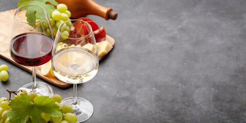 White and red wine glasses, grape and appetizer board - obrazy, fototapety, plakaty