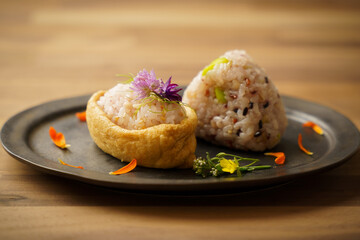 創作いなり寿司とおにぎり、食用花を添えて