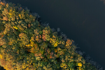 Fototapeta premium Aerial view of beautiful autumn forest on riverbank