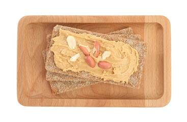 Fresh rye crispbreads with peanut butter on white background, top view