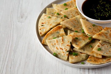 Homemade Scallion Pancakes with Soy Dipping Sauce on a white wooden surface, low angle view. Copy...