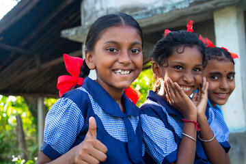 Indian rural school girls sitting at school showing thumbs up