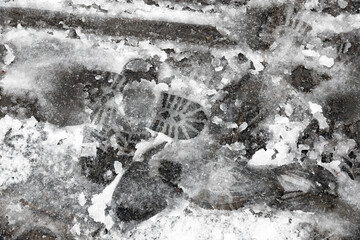 Footprints on melting slushy snow on London street