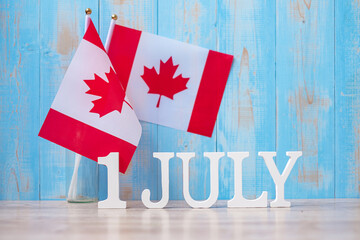 Wooden calendar of July 1st with miniature Canada flags. Canada Day  and happy celebration concepts