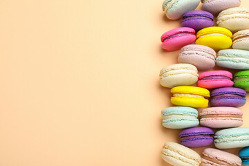 Delicious colorful macarons on beige background, flat lay. Space for text