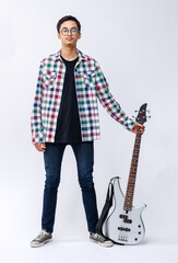 Full-body portrait shot of handsome young teenage musician holding a bass guitar in the studio....
