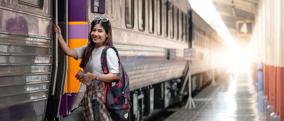Portrait attraction asian woman boarding a train at train station for travel in summer. Travel...