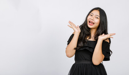 Horizontal portrait shot of happy young girl teenager standing and looking to the camera with raising hand up gesture. There is copy space at the side of the image. Concept of excited promotion