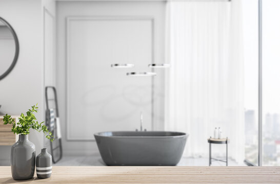 Light wooden bathroom countertop with vase on stylish sunny batroom background with black bath, light wall and city view from huge window. 3D rendering.