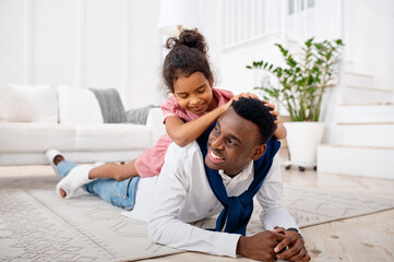 Smiling father and little daughter in living room