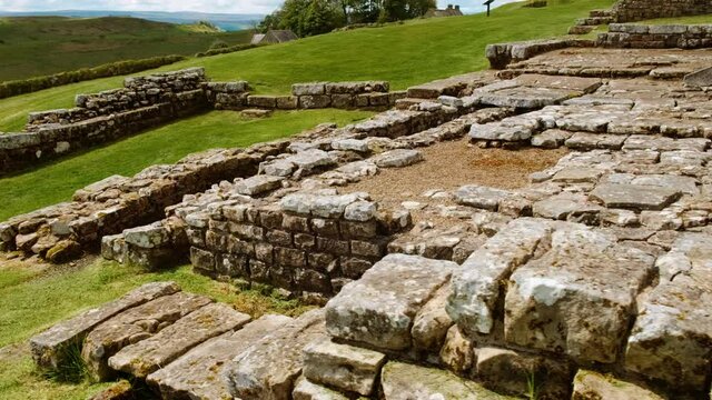 Walking the ruins of Housesteads Roman Fort on Hadrian's Wall, built by the Romans in AD 124 in Northumberland, England, UK. Hadrian's Wall is a UNESCO World Heritage Site