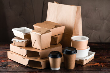 Eco craft paper tableware. Paper cups, dishes, bag, fast food containers, box for delivery food on wooden background