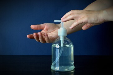 A woman's hand presses on the soap dispenser. Clean hands and good health. Hand washing.