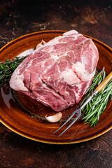 Fresh raw Pork Neck meat steak in rustic plate. Dark background. Top view