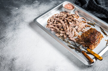 Bbq grilled puilled pork meat in a steel baking tray. White background. Top view. Copy space