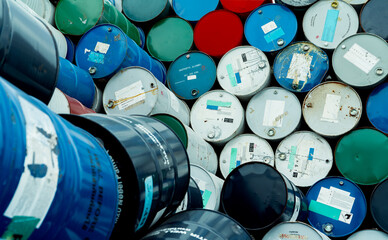 Old chemical barrels. Blue, red, and green chemical drum. Steel tank. Hazard chemical barrel with flammable liquid warning label. Industrial waste. Isopropyl alcohol and aluminized orgonosol barrels.