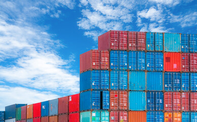 Red and blue logistic container against blue sky. Cargo and shipping business. Container ship for...
