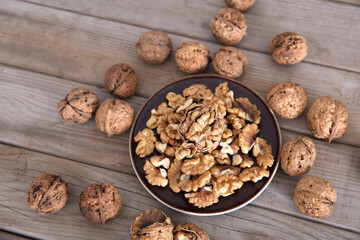 A plate of walnuts surrounded by walnuts