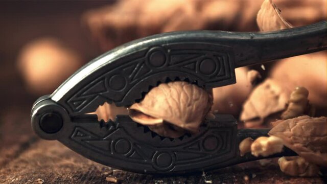 Super slow motion walnut pricked nut-fol. On a wooden background. Filmed on a high-speed camera at 1000 fps.