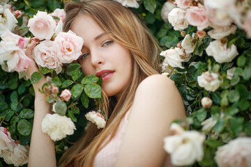 Beautiful young woman smells a rose flower. High quality photo