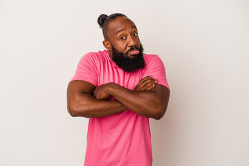 African american man with beard isolated on pink background shrugs shoulders and open eyes confused.