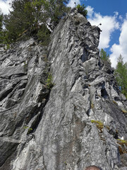 View from the water on the steep slope of the flooded Marble Canyon in the Ruskeala Mountain Park on a sunny summer day.
