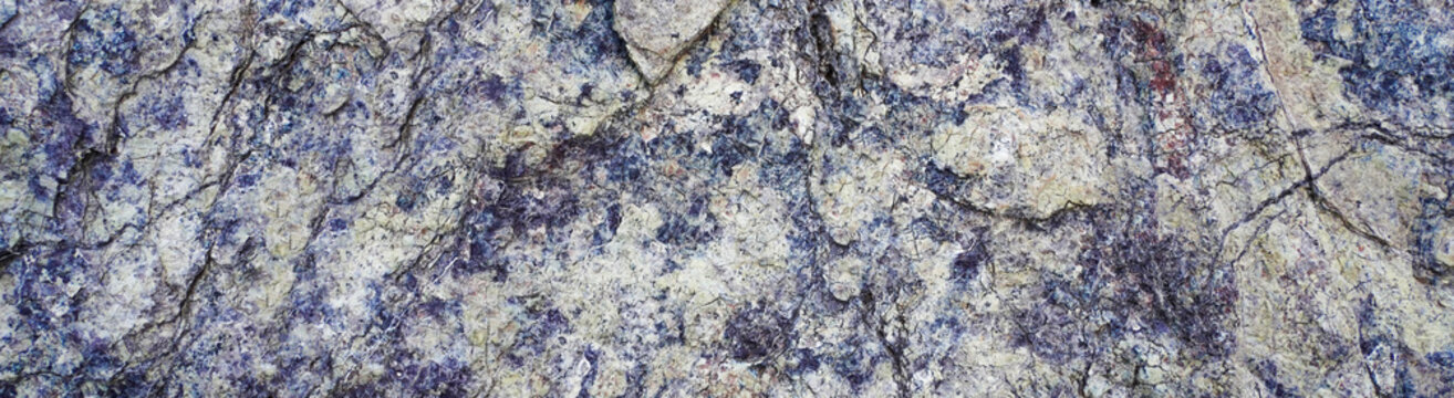 Texture of natural stone rock, background wallpaper white, blue and violet blotches on the surface. Horizontal rectangular photography