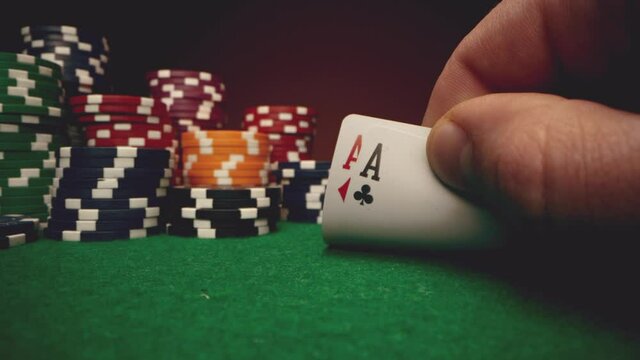 Poker player shows his cards two aces on poker table 