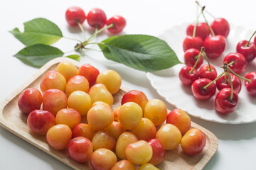 Fresh cherries with cherry leaf isolated on a white background.