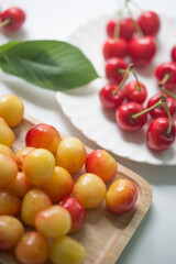 Naklejka na ściany i meble Fresh cherries with cherry leaf isolated on a white background.