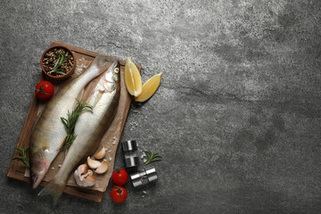 Fresh raw pike perches and ingredients on grey table, flat lay with space for text. River fish