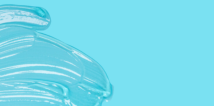Transparent clear liquid gel cosmetic spot drops texture blue solid color background