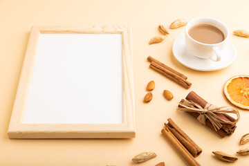 Composition with wooden frame, almonds, cinnamon and cup of coffee. mockup on orange background. top view, copy space.