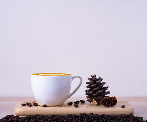 A glass mug of hot latte coffee art with coffee beans and props on wooden table. Breakfast in the morning love coffee break concept. Copy space for text.