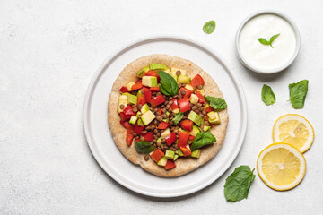 Pita bread with lentil, vegetables and yogurt dressing. Green lentils, bell peppers, zucchini