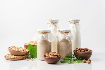 Plant based milk in glass bottles on white background. Vegan non dairy alternative lactose free milk