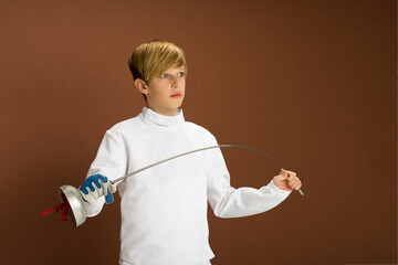 Boy fencer in white fencing costume with rapier