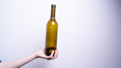 a woman's hand holding a glass bottle