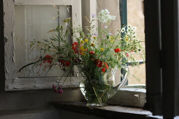Field bouquet standing on a antic tuscan windowsill 