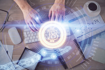 Double exposure of man's hands typing over computer keyboard and crypto currency theme hologram drawing. Top view. Blockchain concept.
