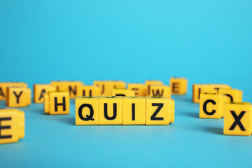 Yellow cubes with word Quiz on light blue background. Space for text