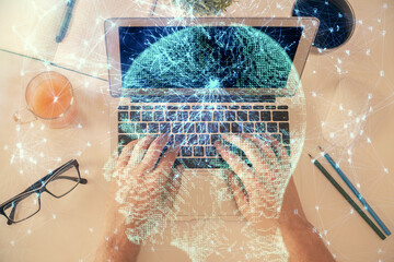 Double exposure of man's hands typing over computer keyboard and brain hologram drawing. Top view. Ai and data technology concept.